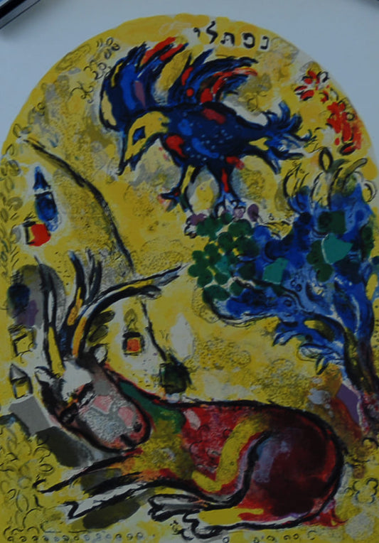 マルク・シャガール 【ネプタリ族 画集エルサレムウインドウより】オリジナルリトグラフ版画 【額付】 サイズ30x21cm 額サイズ50x41cm   シャガールは、絵画版画と同時に壁画や教会等のステンドグラスも制作した。1959年に、シャガールはエルサレムのユダヤ教の礼拝堂を飾る12枚のステンドグラスを制作して、その記念に1962年に14枚のオリジナルリトグラフ版画入りの画集【エルサレムウインドウ】を出版した。この画集には、教会の12ステンドグラスと同じ古代ユダヤの12族の物語の絵とそれ以外の2点のオリジナルリトグラフ版画が挿入された。本作はその画集エルサレムウインドウのオリジナルリトグラフ版画を額に入れた作品だ。作家のオリジナルリトグラフ版画の証として画集の最後のページに作家サインがいれてある。